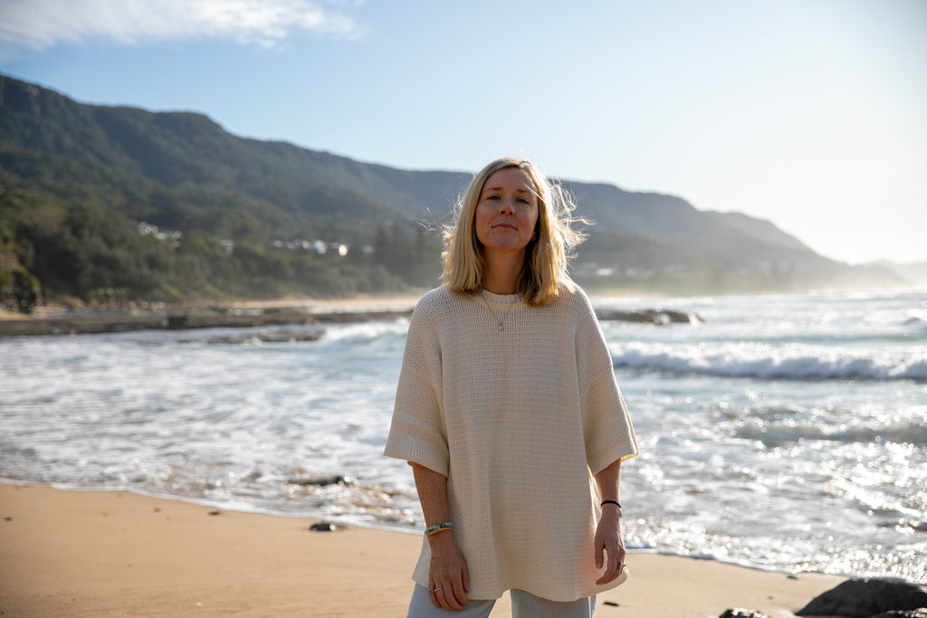 Woman standing on a beach with mountains in the background