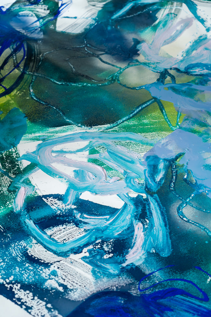 Vibrant blue and green paints being mixed to create a floral abstract artwork, a symphony of colour by Victoria Wilson.