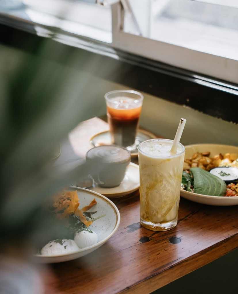 Café setting with drinks and snacks on a wooden table.