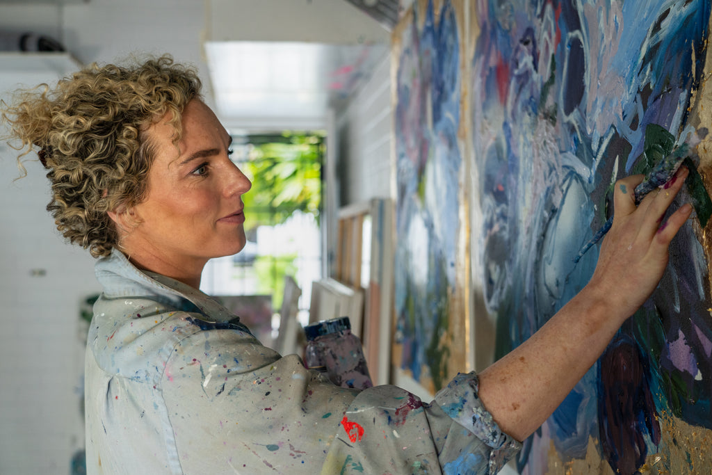 Victoria Wilson applying acrylic paint for additional touches on her latest abstract artwork, adding depth and detail to the piece.