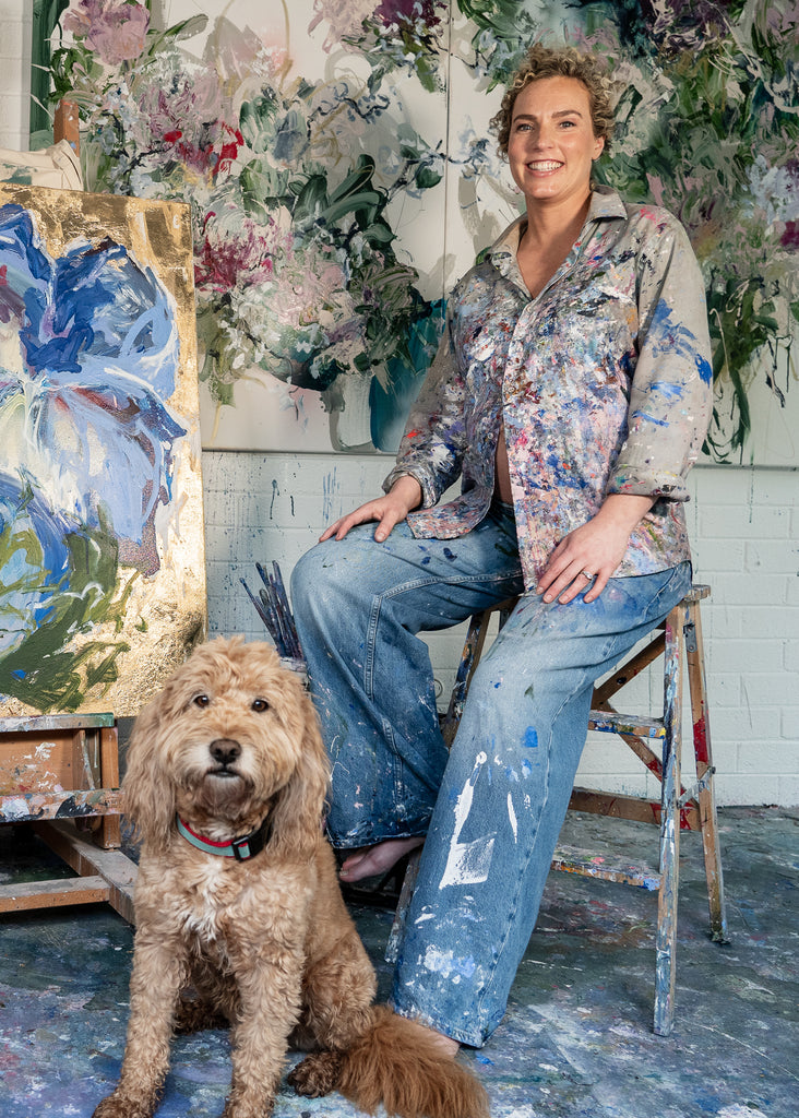 Victoria Wilson with her dog Walter, sharing a moment of joy in the studio, capturing the bond between artist and pet.