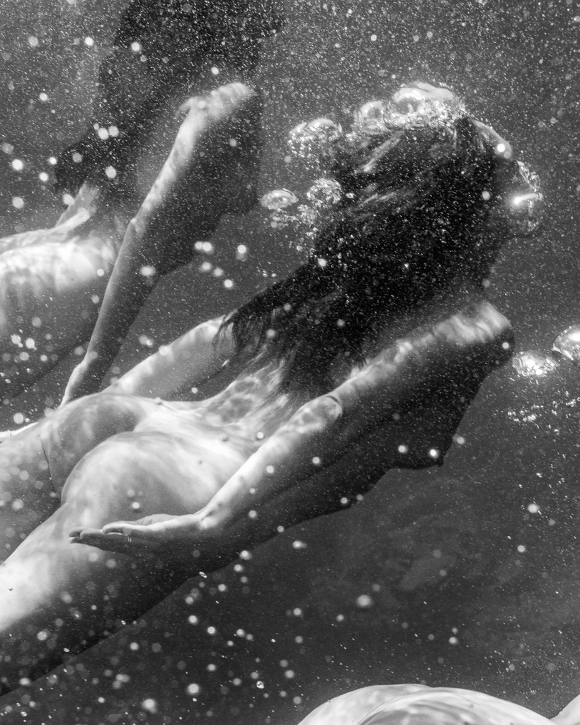Black and white underwater scene with women swimming