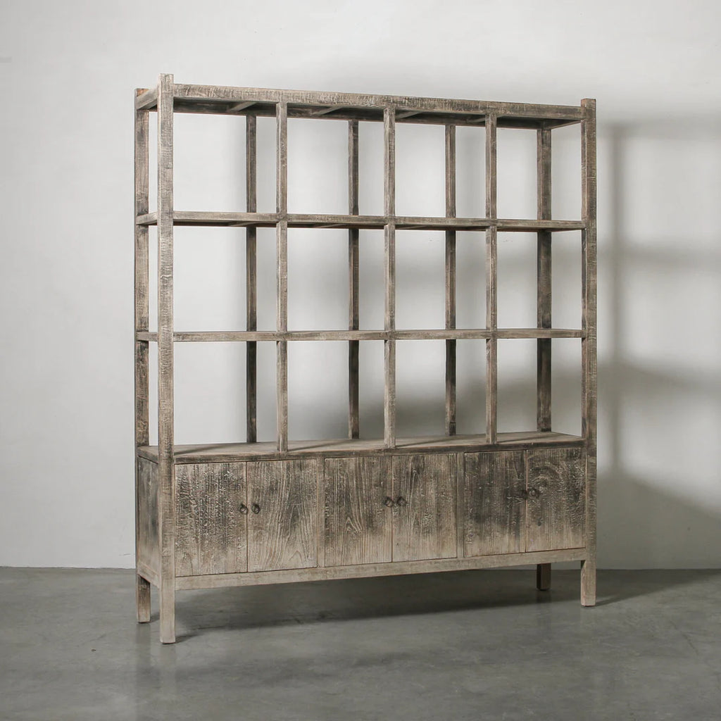 Wooden bookshelf with grid design against a plain wall