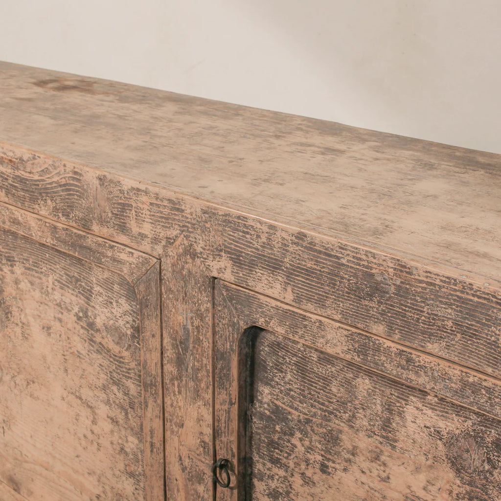 Close-up of a wooden cabinet with a rustic finish.
