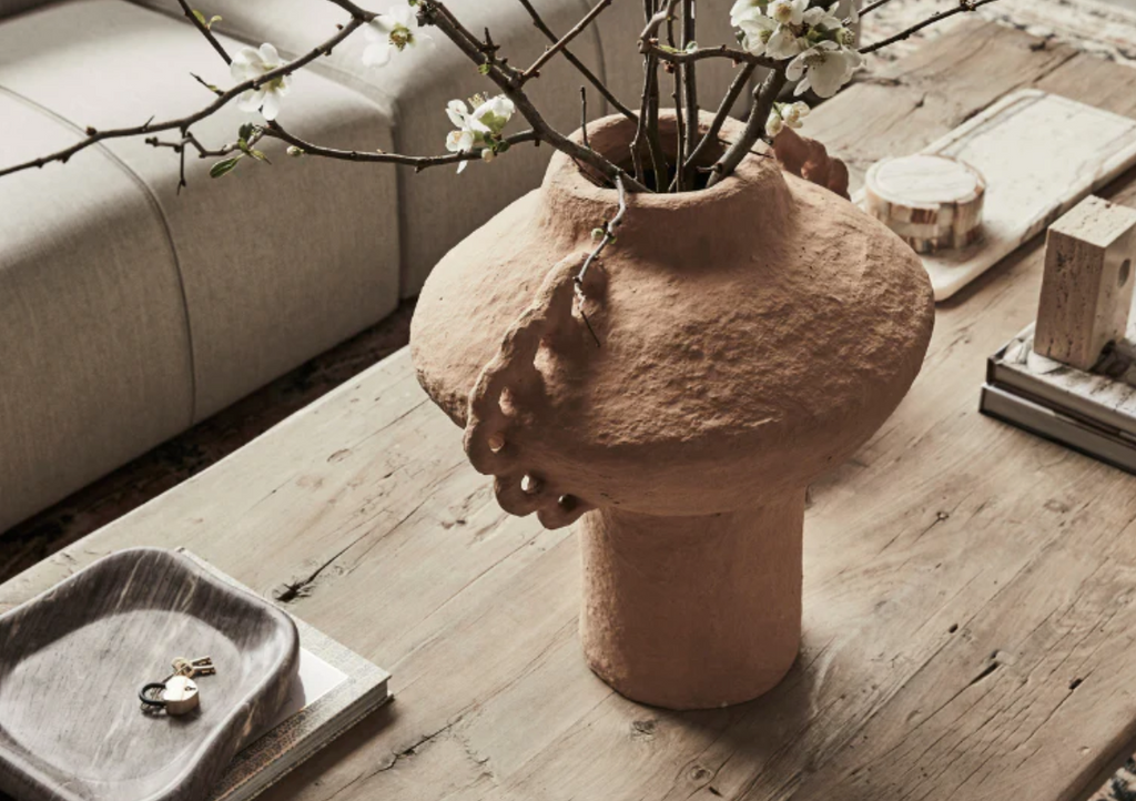 Decorative vase with branches and flowers on a wooden antique table