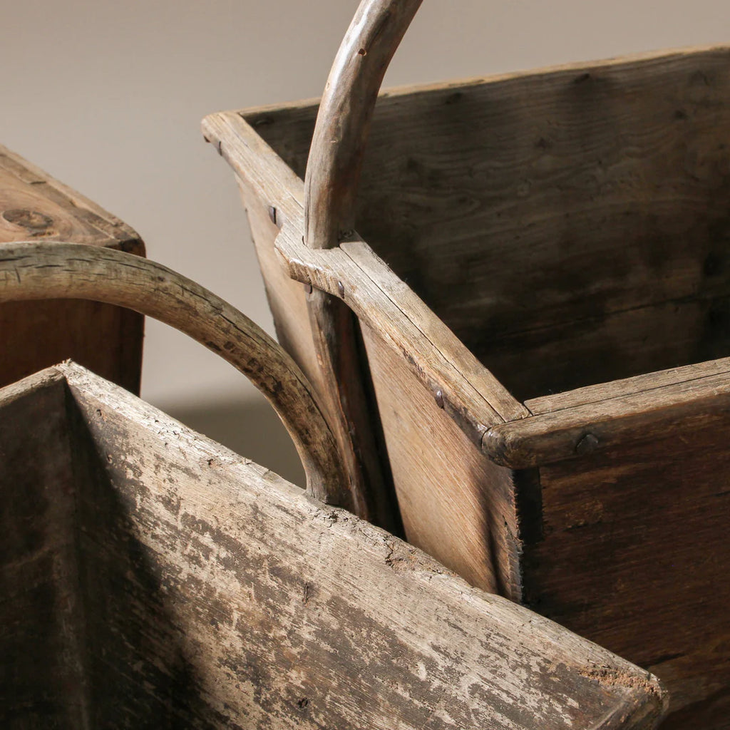 Two rustic wooden crates with handles on a neutral background