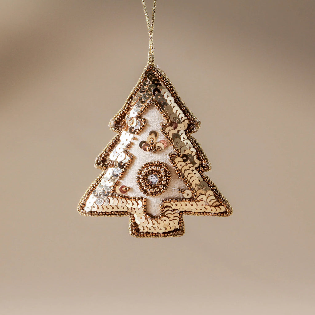 Decorative Christmas tree ornament with sequins on a beige background