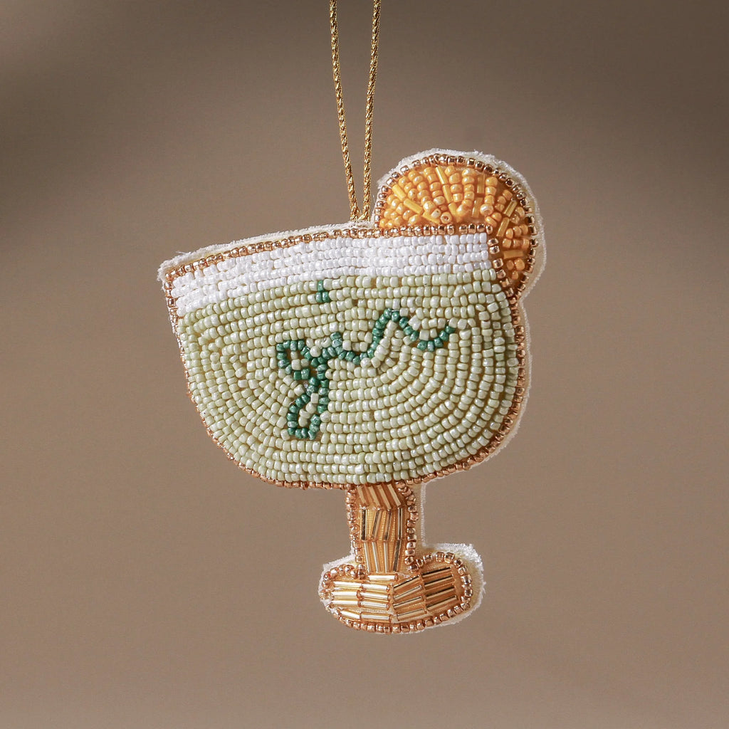 Decorative beaded ornament shaped like a cocktail glass with corn on a brown background