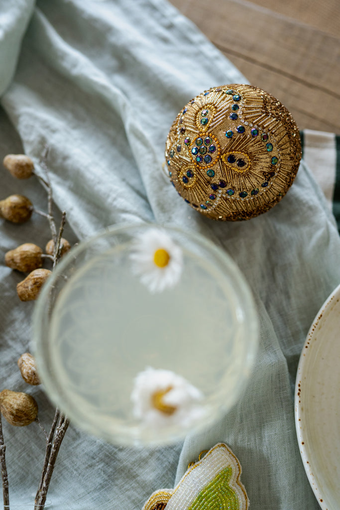 Decorative Christmas decoration with gemstones on a light fabric background and a cocktail