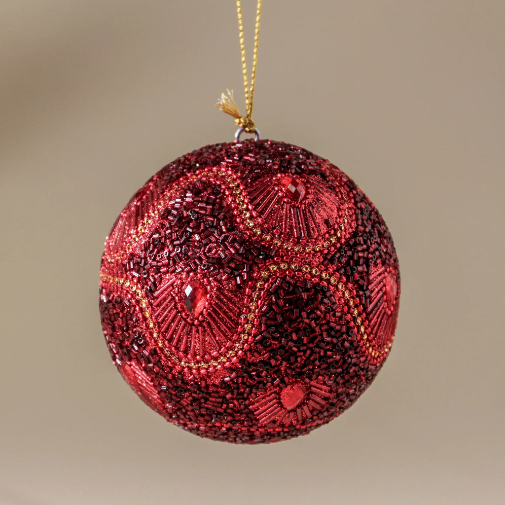 Decorative red ornament with gold accents on a beige background