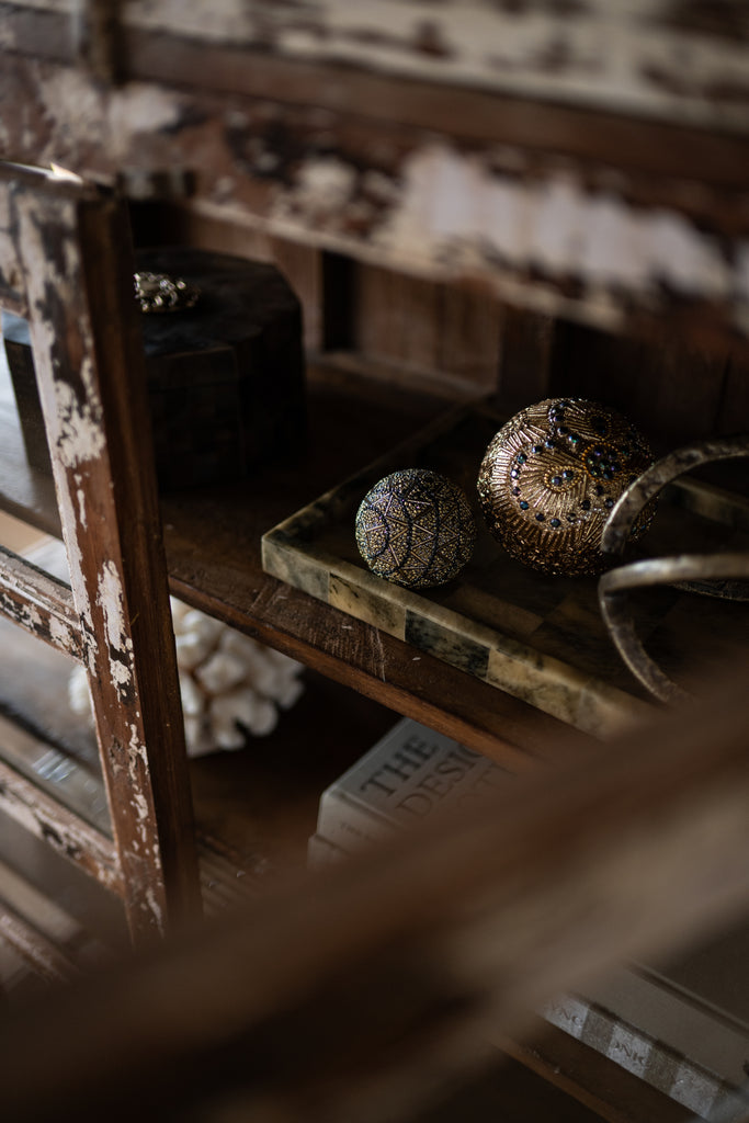 Decorative Christmas items on a rustic wooden shelf with a blurred background