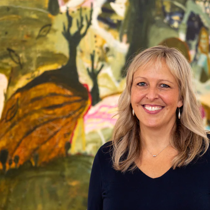Woman standing in front of a colorful abstract painting