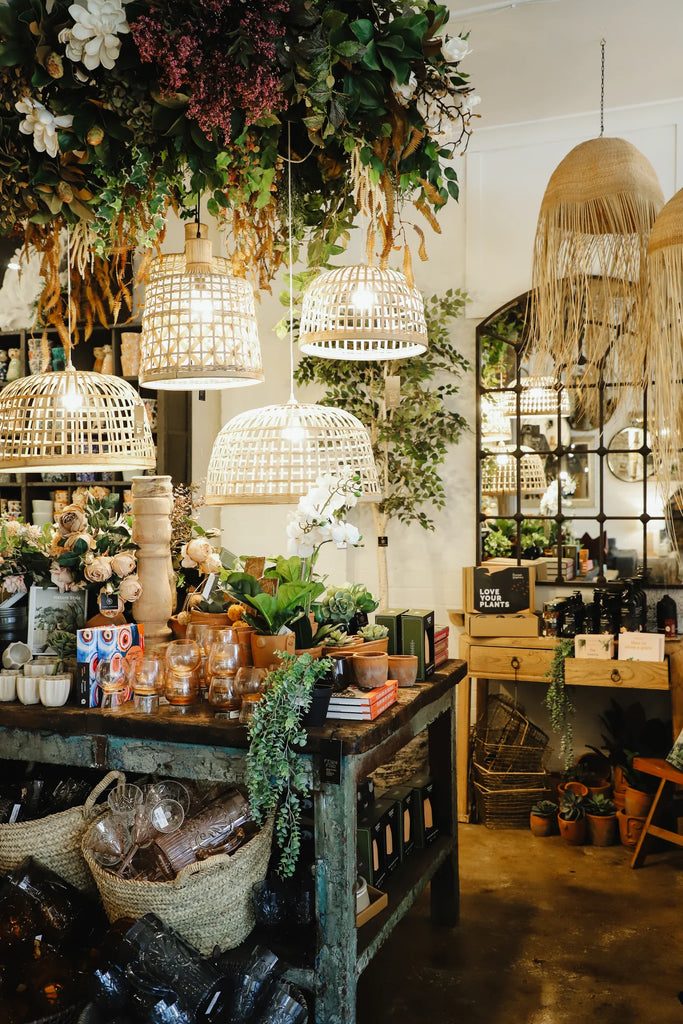Decorative interior with hanging lights, plants, and a counter displaying various items.
