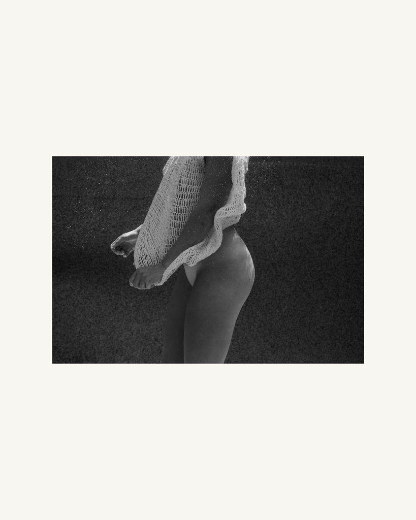 Black and white image of a person wearing a textured garment.