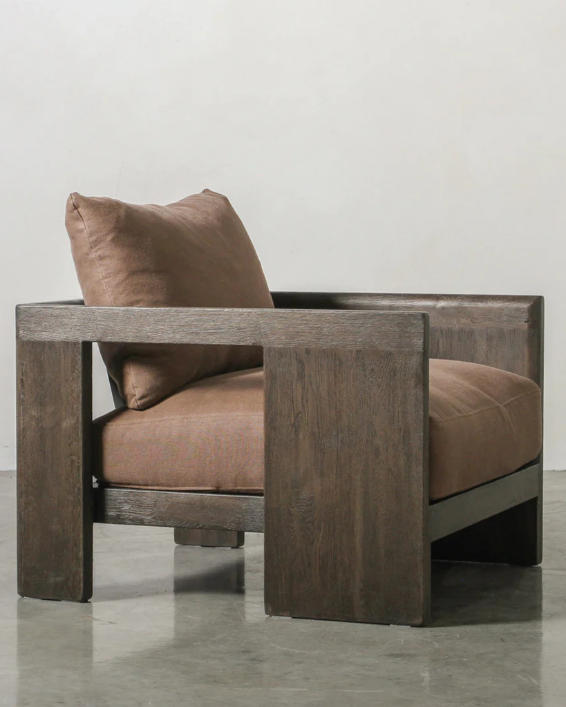 Brown armchair with wooden frame on a light gray background