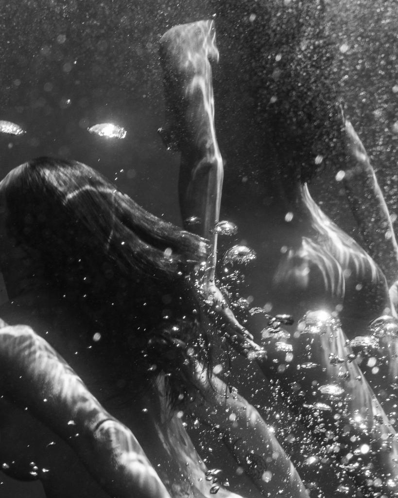 Person underwater with bubbles and water droplets