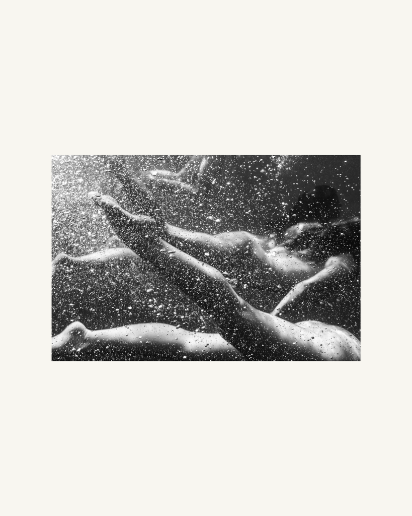 Black and white image of underwater scene with bubbles and light