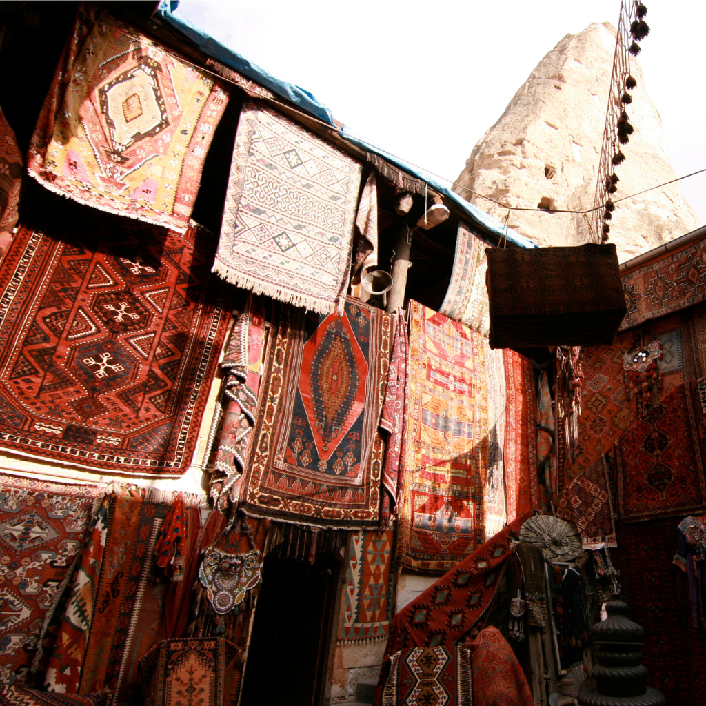 Display of various patterned rugs with a architectural background