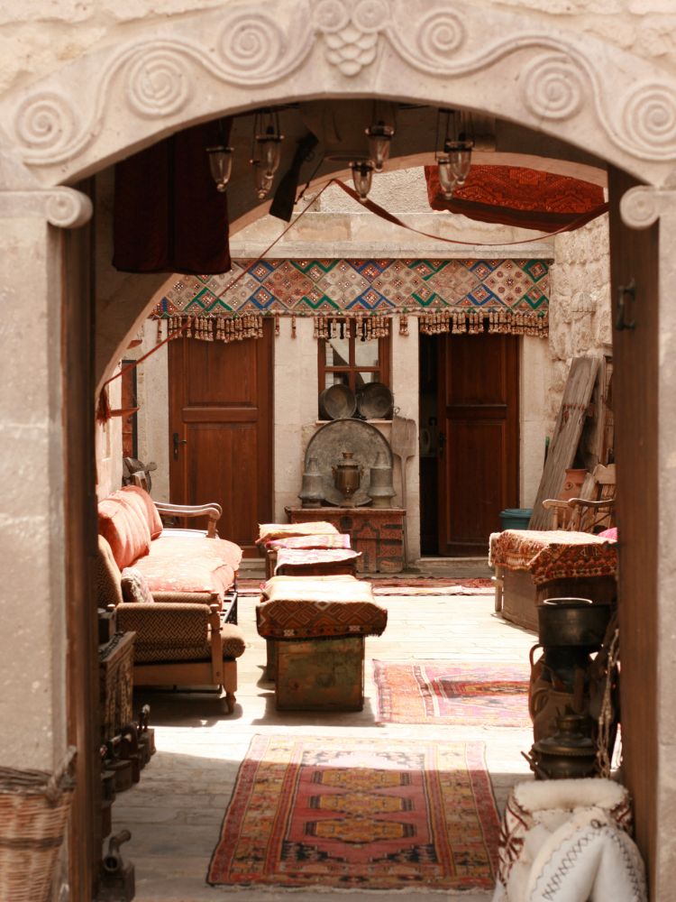 Decorative Turkish area with patterned rugs, chairs, and a stone archway.