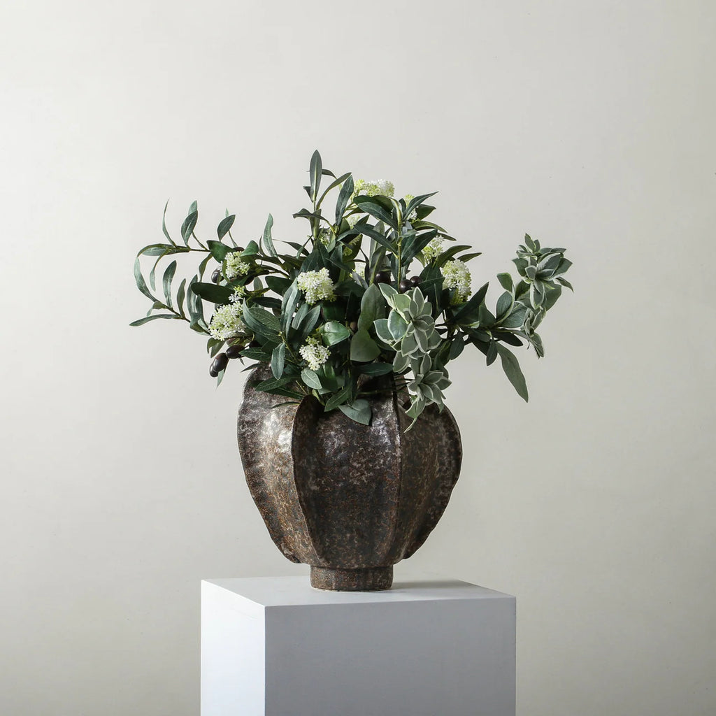 Decorative vase with greenery on a light gray background