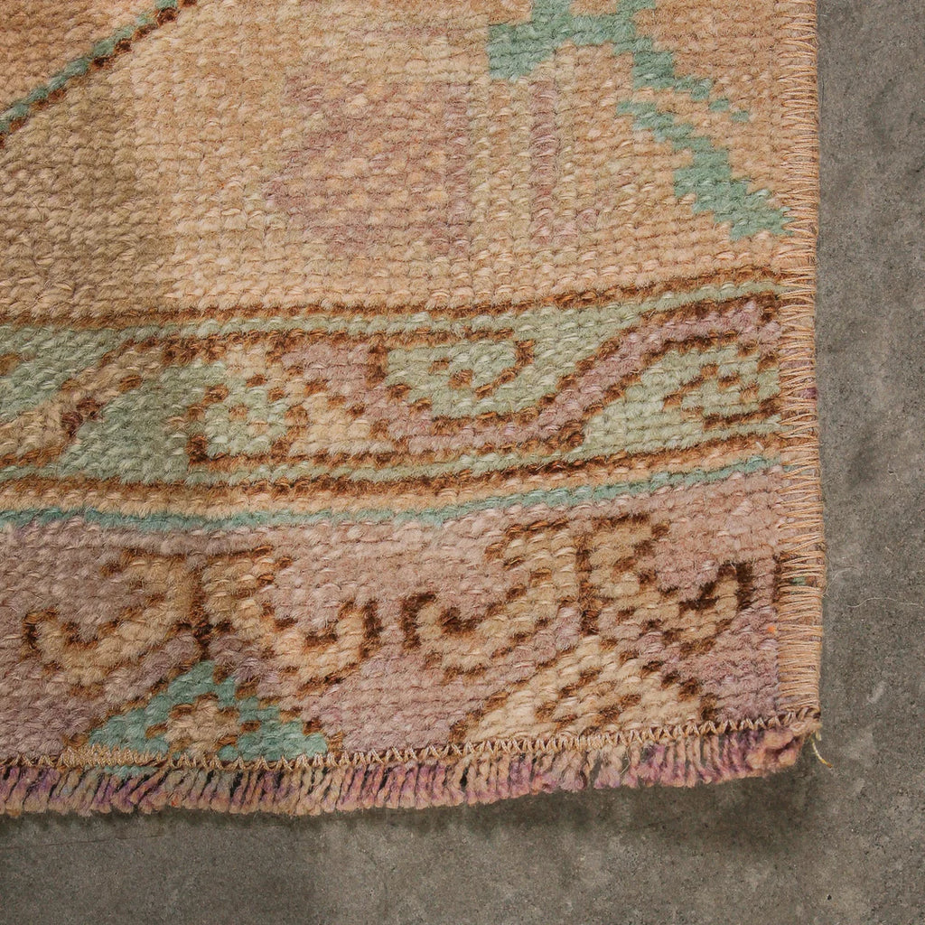 Close-up of a textured rug with intricate patterns on a concrete floor.